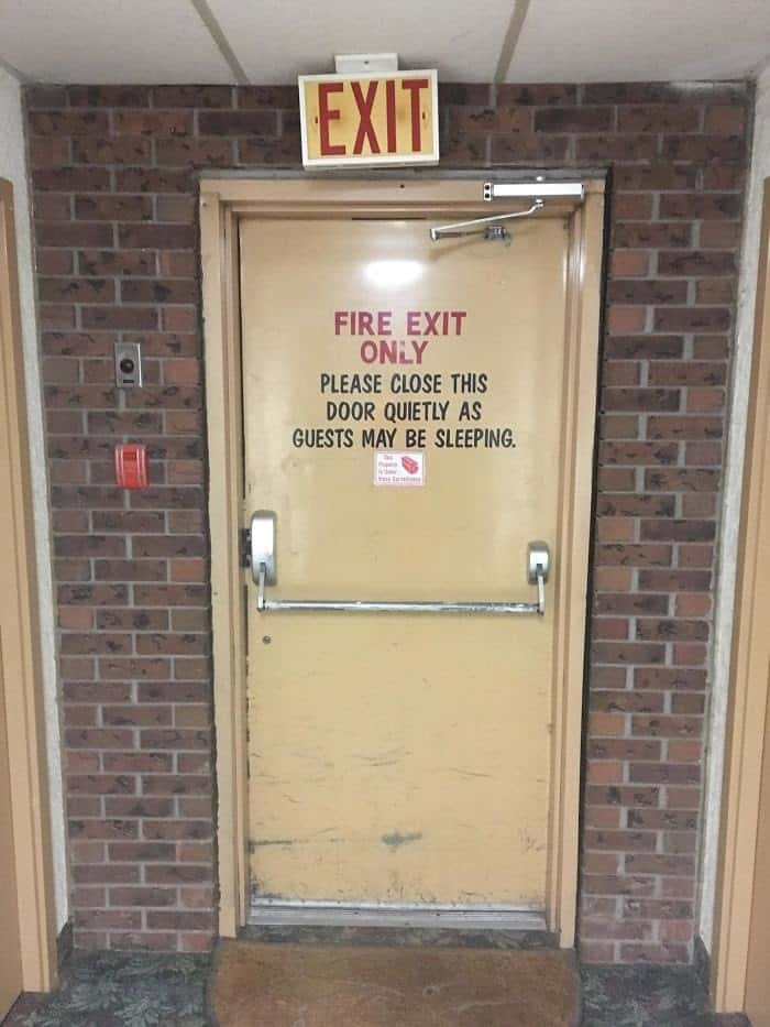 Photograph of a fire exit door. The message on the door reads, "Fire Exit Only. Please close this door quietly as guests may be sleeping."
