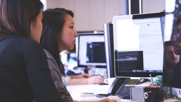 Two people looking at a computer screen.